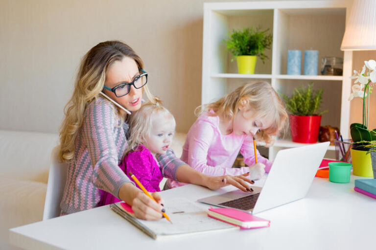 busy woman trying to work while babysitting two kids